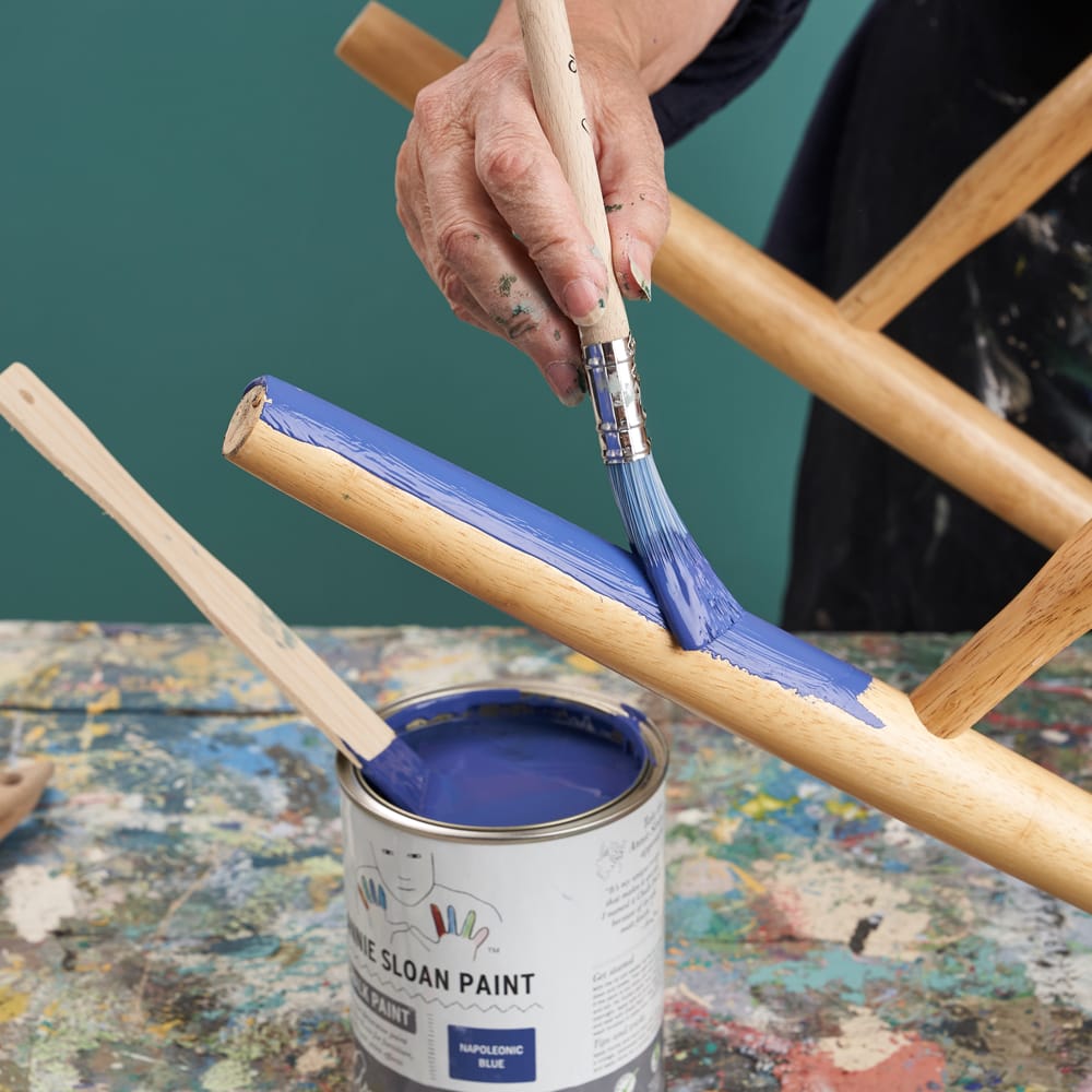 Annie Sloan painting a dining chair using Chalk Paint® in Napoelonic Blue