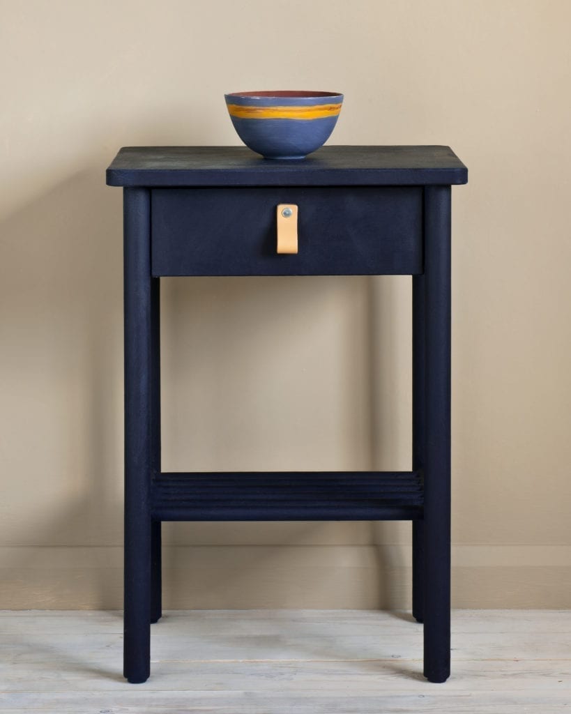 Side table painted with Chalk Paint® in Oxford Navy, an inky, traditional navy blue against a wall of Country Grey
