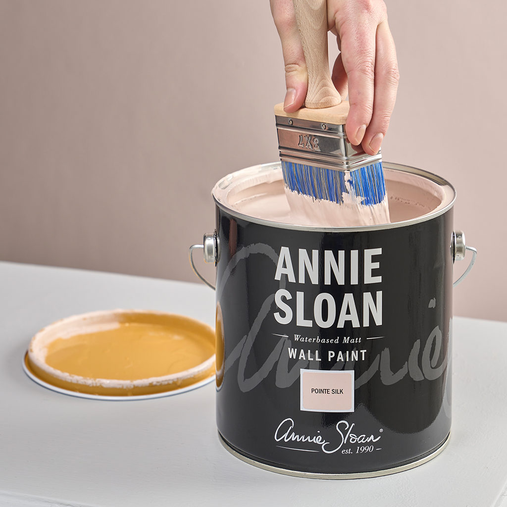 Product Shot of Annie Sloan Wall Paint Brush being dipped in tin of Annie Sloan Wall Paint in Pointe Silk