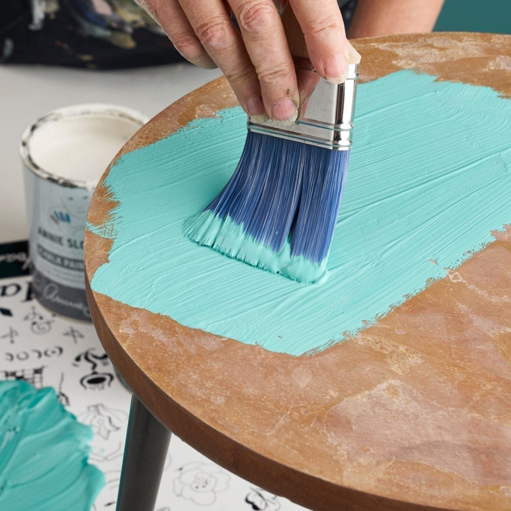 Annie Sloan using Chalk Paint furniture paint in a mix of Florence and OId White to paint a table using a Flat Brush