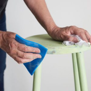 Annie Sloan sanding a two colour distress on a stool painted with Chalk Paint in Lem Lem and Aubusson Blue CREDIT Tina Hillier with Oxfam