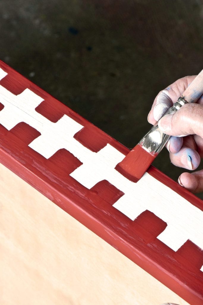 Annie Sloan using the Large Flat Detail Brush with Chalk Paint® in Burgundy on Old White Graphic Plan Chest Credit CICO Books Christopher Drake