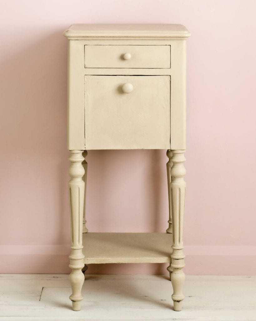 Side table painted with Chalk Paint® in Country Grey, a rustic putty cream beige against a light pink wall of Antoinette