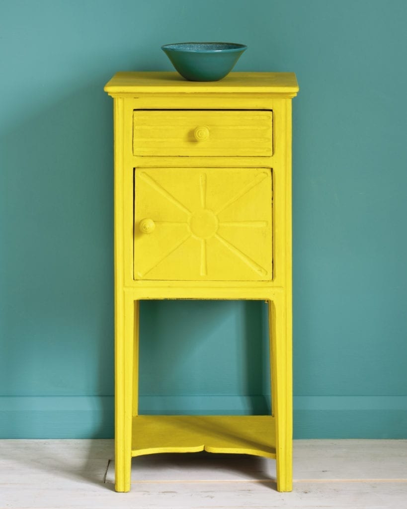 Side table painted with Chalk Paint® in English Yellow, a bright traditional yellow against a wall of Provence.