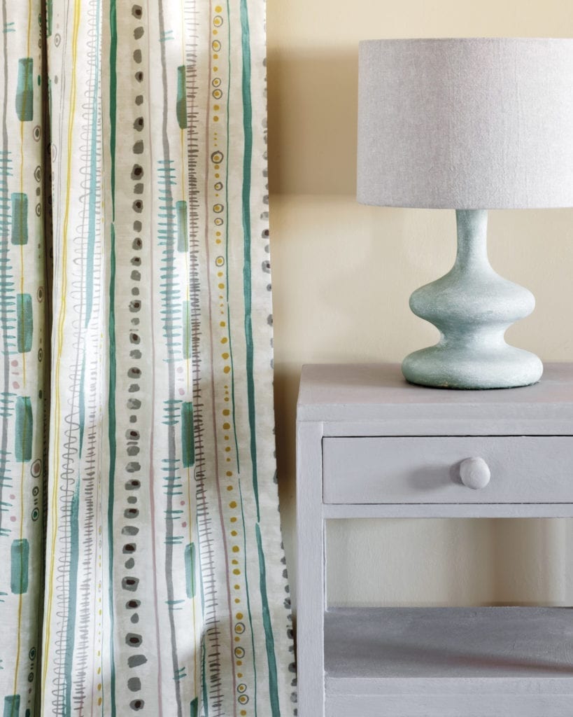 Side table painted with Chalk Paint® in Paloma, I litre tin of Paloma Chalk Paint® furniture paint by Annie Sloan, a sophisticated warm grey taupe lilac. Curtain in Piano in Provence and lampshade in Linen Union in Old White + Paloma