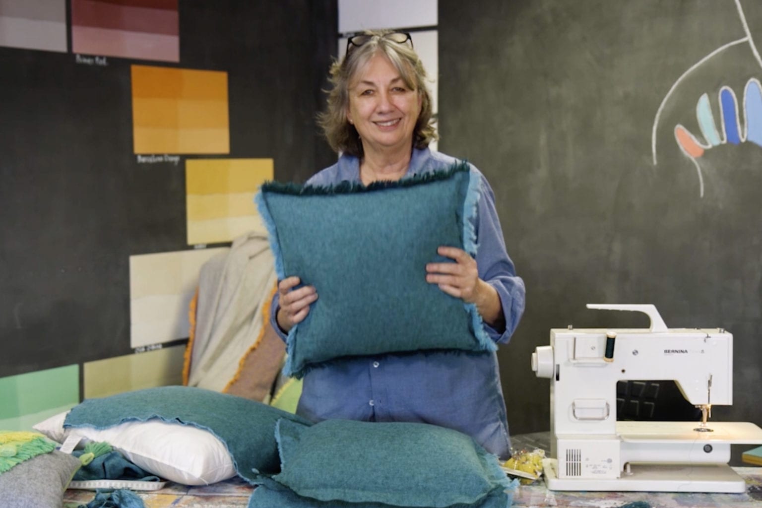 Annie Sloan sewing a tassel fringed cushion using her fabric Linen Union in Provence + Aubusson Blue