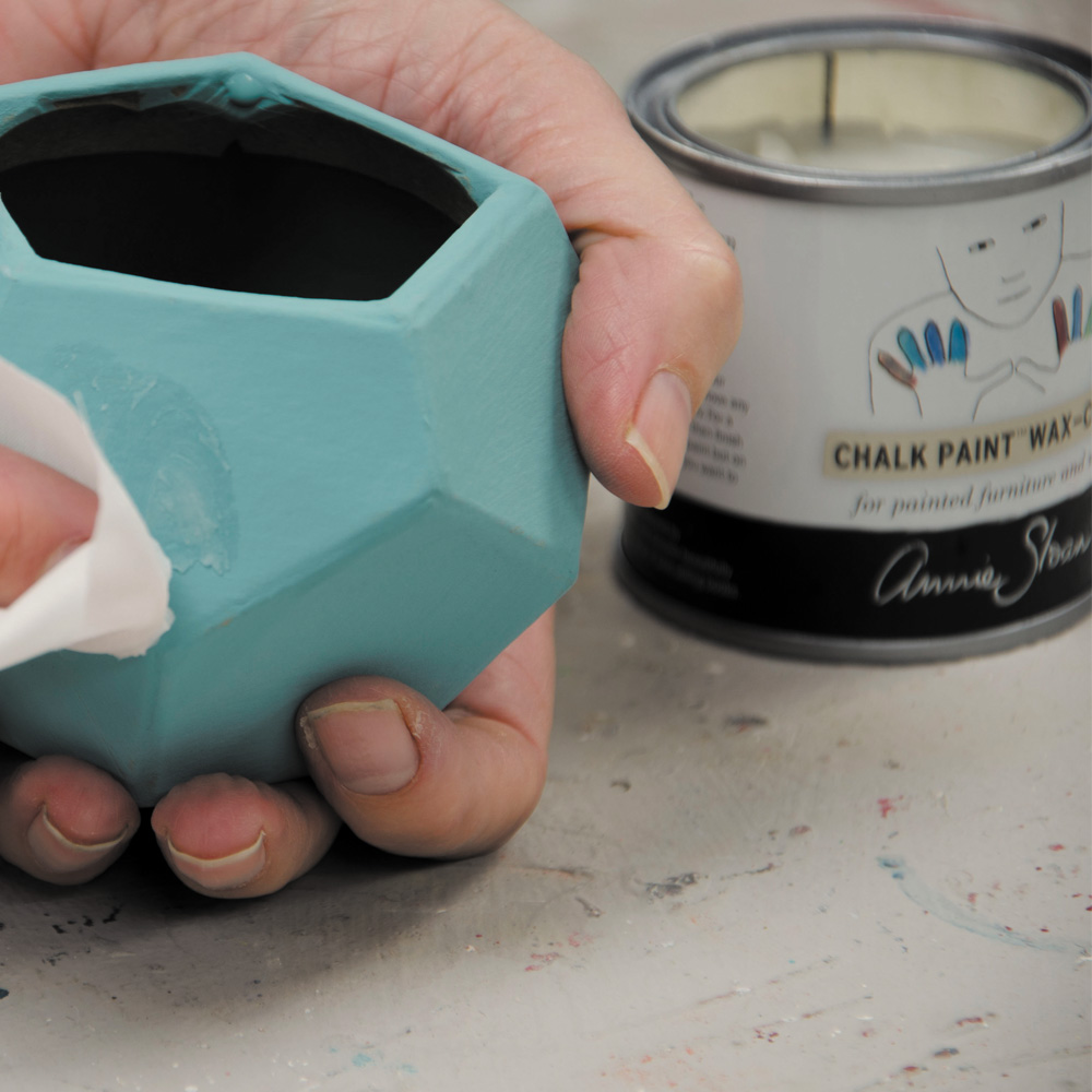 A close up of Annie Sloan's hands applying Chalk Paint® Wax