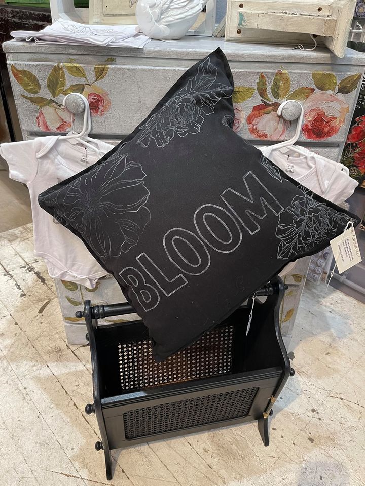 Black pillow with stenciled word Bloom