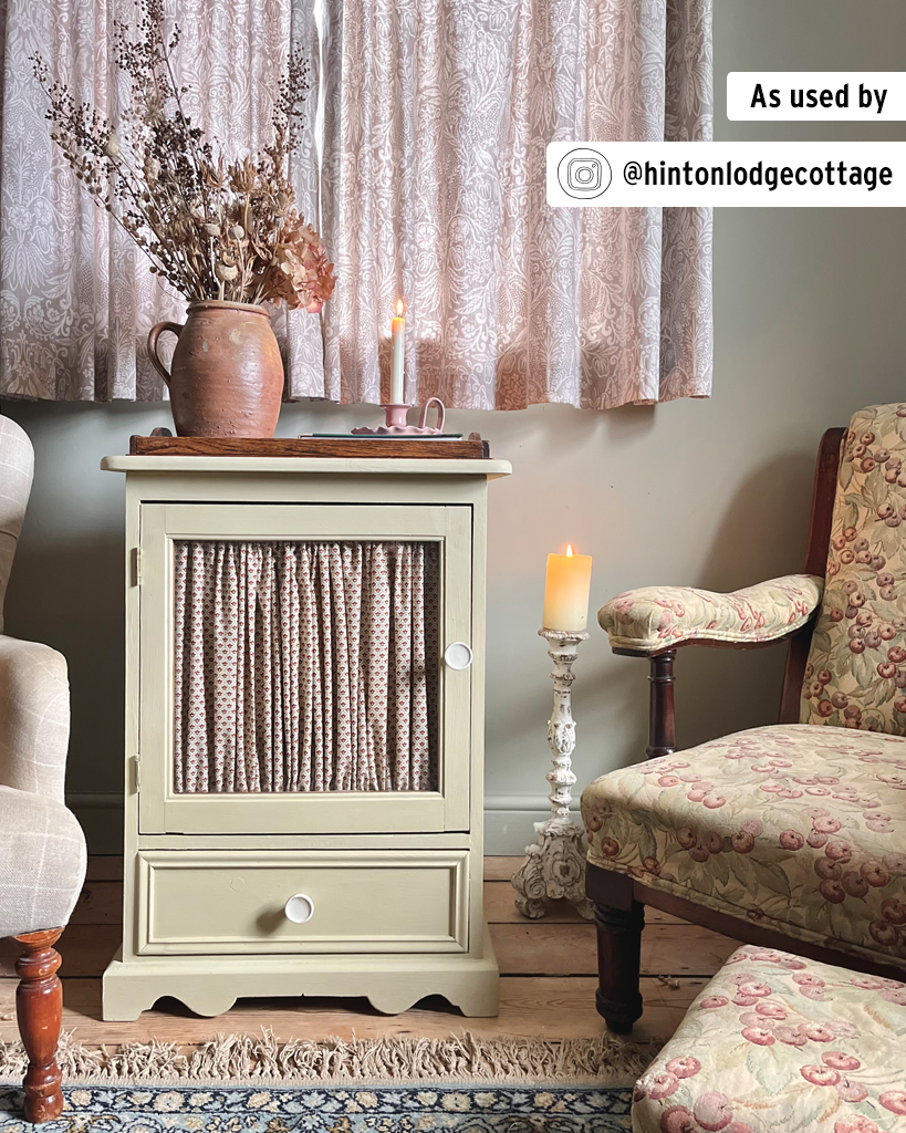 Cottage-Style Side Table with Curtained Glass Panel Painted in Versailles Chalk Paint Between Two Armchairs