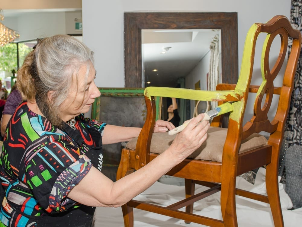 Annie Sloan at the Canada flag ship store grand opening painting a chair with Chalk Paint® furniture paint in Firle