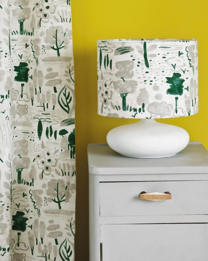 Side table painted with Chalk Paint® in Paris Grey, a soft and slightly bluish grey against English Yellow Wall Paint. Dulcet in Old White curtain and lampshade