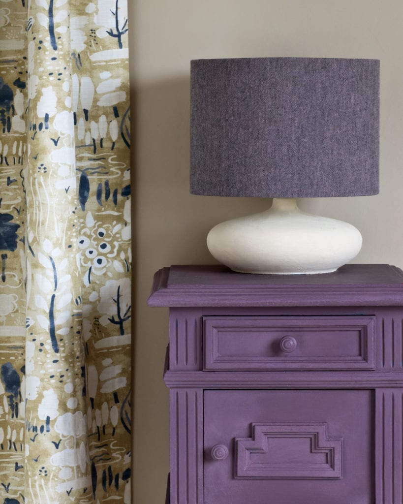 Side table painted with Chalk Paint® in Rodmell, a dusty, damson purple made in collaboration with Charleston Farmhouse. Dulcet in Old Violet curtain and Linen Union in Emile + Graphite lampshade