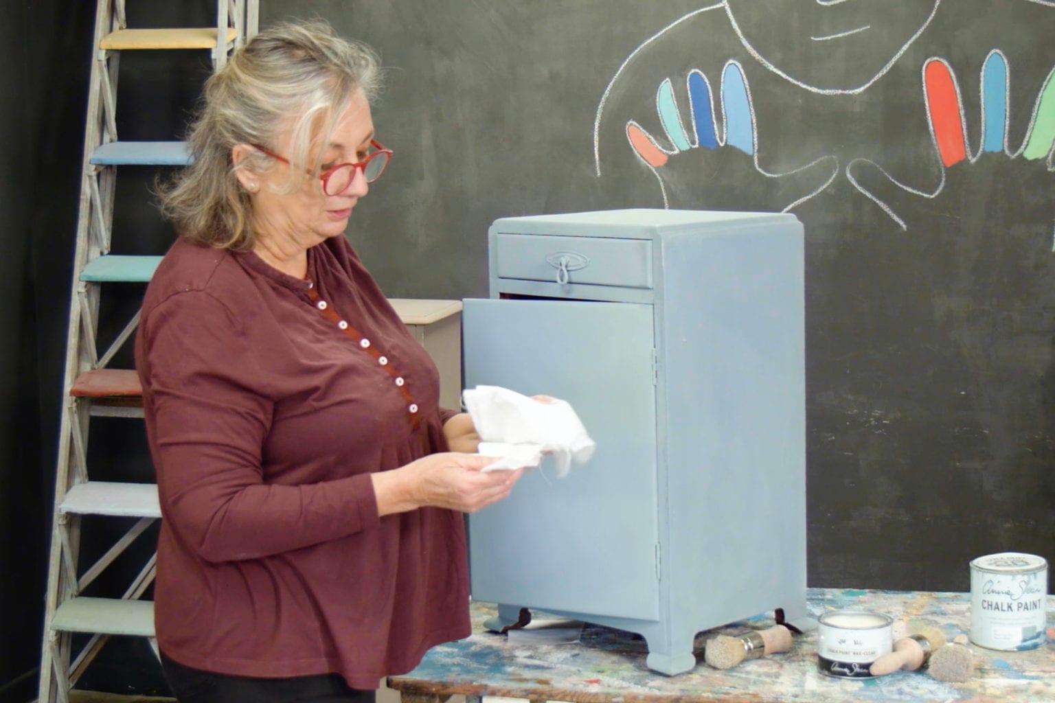 Annie Sloan showing how to use Clear Chalk Paint® Wax on a cabinet painted with Paris Grey