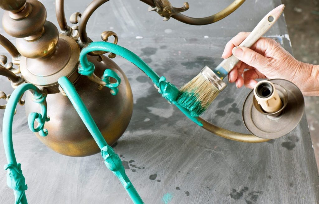 Annie painting a chandelier with Chalk Paint® in Florence. Taken from Annie Sloan Paints Everything published by Cico books photos by Christopher Drake