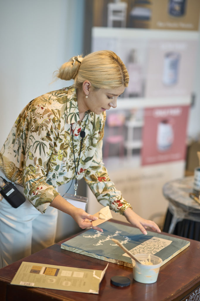 Furniture painter, Kacha, giving a stencilling demonstration on stage at the Big Paint event in New Orleans