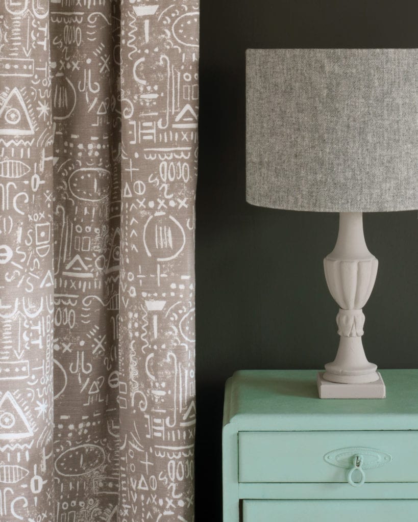 Side table painted with Chalk Paint® in Duck Egg Blue, a greenish soft blue against a black wall of Graphite. Tacit in French Linen curtain and Linen Union in Old White + French Linen Lampshade