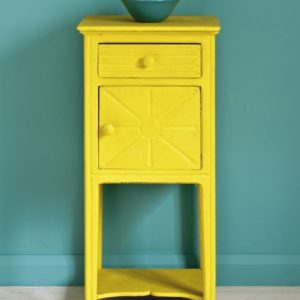 Side table painted with Chalk Paint® in English Yellow, a bright traditional yellow against a wall of Provence.