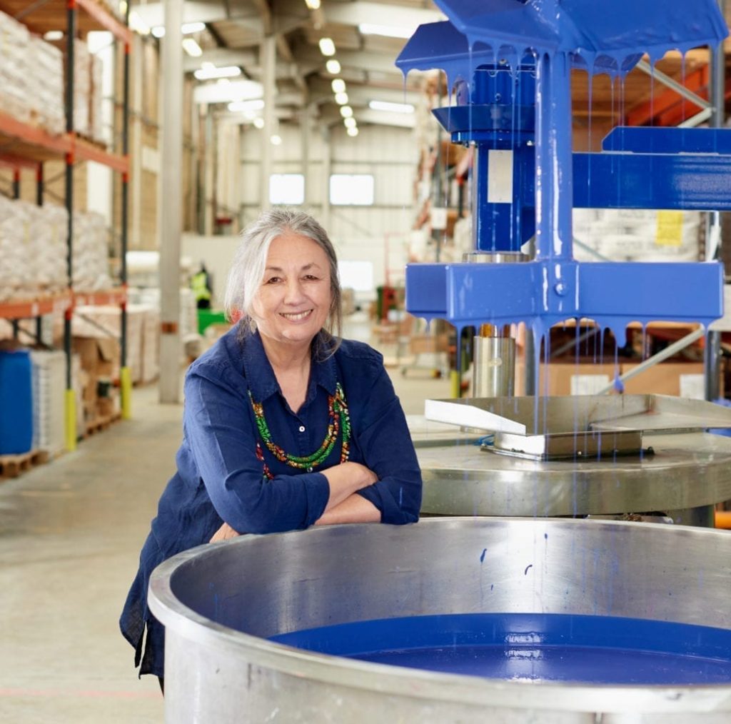 Annie Sloan by a Chalk Paint® in Napoleonic Blue paint vat in her Oxford warehouse