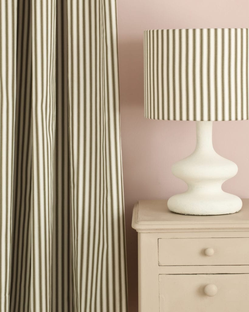 Side table painted with Chalk Paint® in Country Grey, a rustic putty cream beige against a light pink wall of Antoinette. Ticking in Olive curtain and lampshade