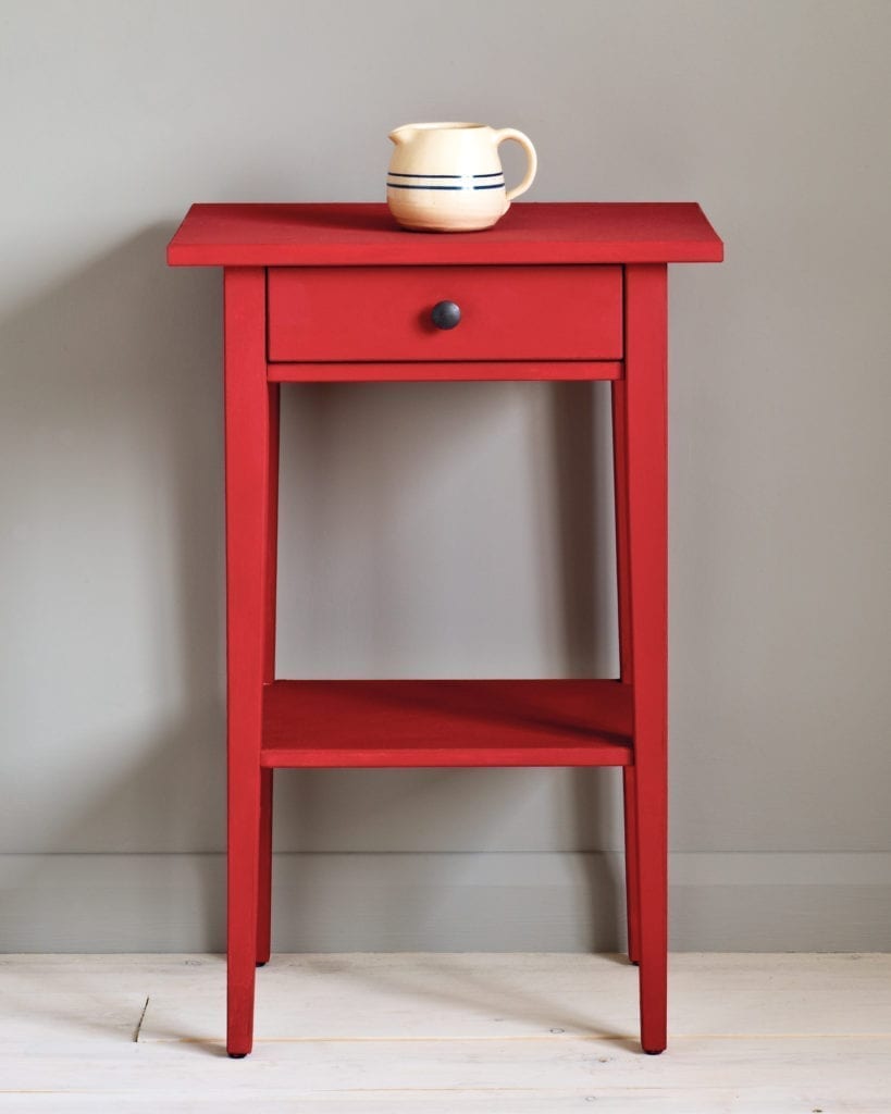 Side table painted with Chalk Paint® in Emperor's Silk, a bright pure red against a wall painted with Paris Grey