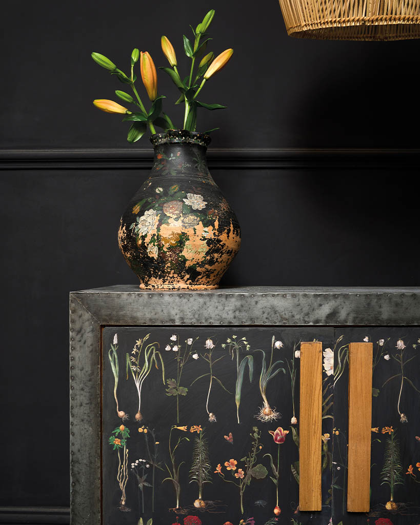 Transfert Formal Garden d’Annie Sloan appliqué sur un meuble bas, avec fleurs dans un vase