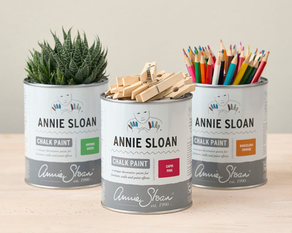 Image de trois pots de peinture Annie Sloan recyclés pour y mettre une plante, des pinces à linge et des crayons de couleur