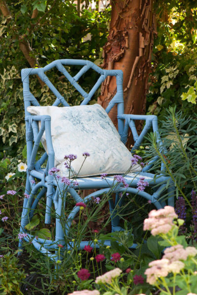 Annie Sloan Chalk Paint Chair in Greek Blue and Old White Outside Surrounded by Flowers