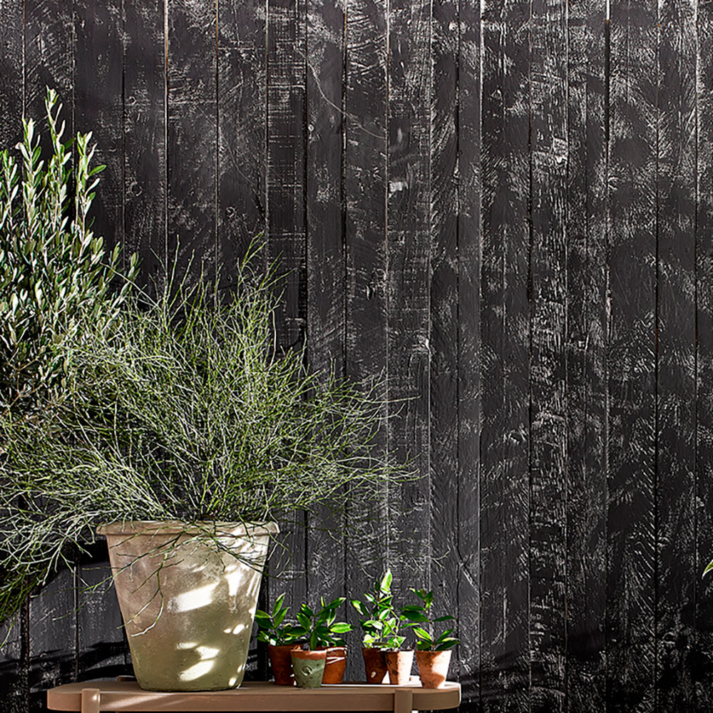 Close up of the Athenian Black Chalk Paint® fence with potted plants