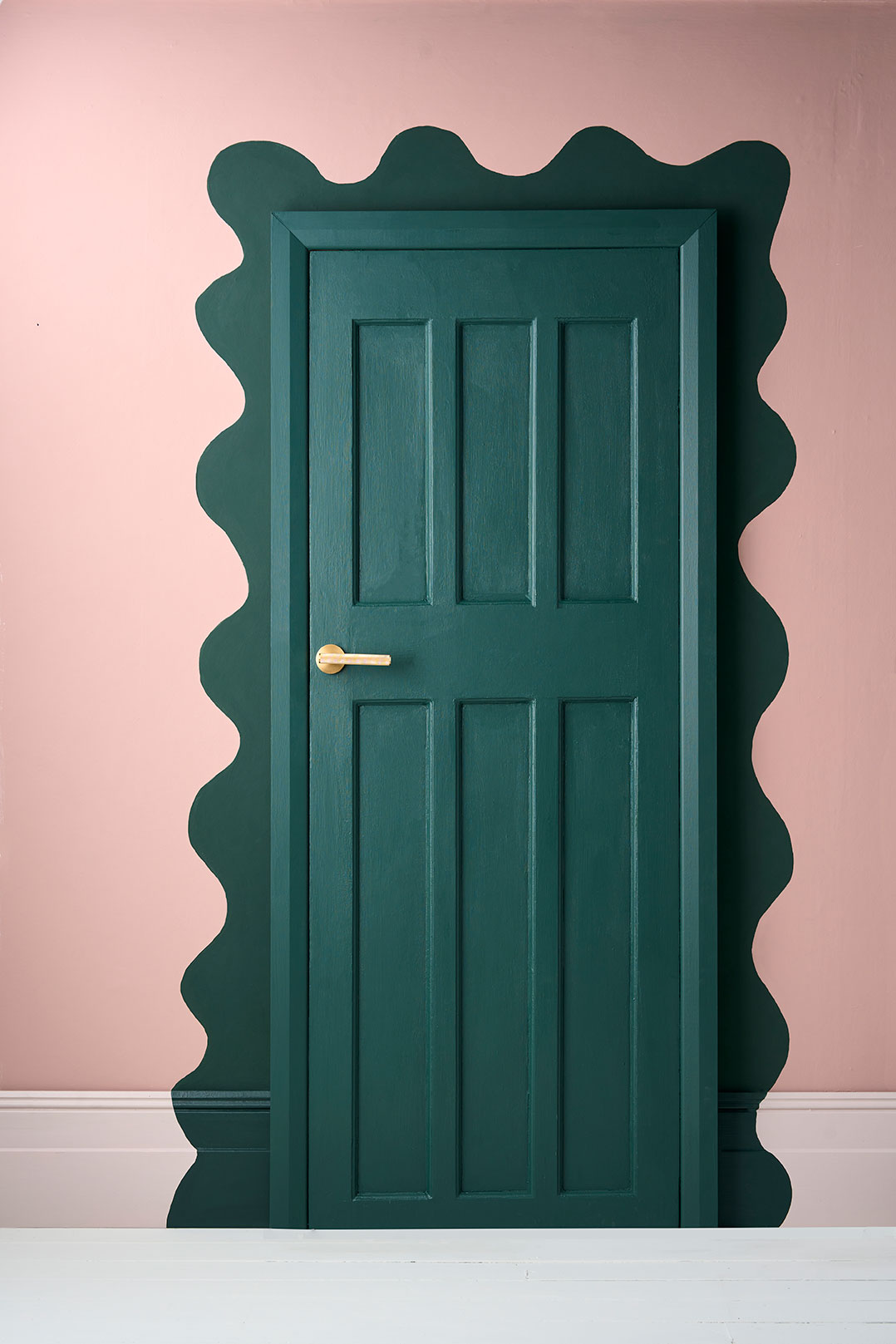 Zbliżenie na wzór namalowany farbą ścienną Annie Sloan w kolorze Knightsbridge Green wokół framugi drzwi