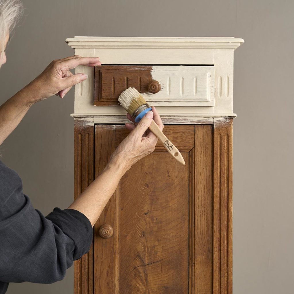 Annie Using Chalk Paint Brush to Paint a Small Cabinet in Old Ochre Chalk Paint
