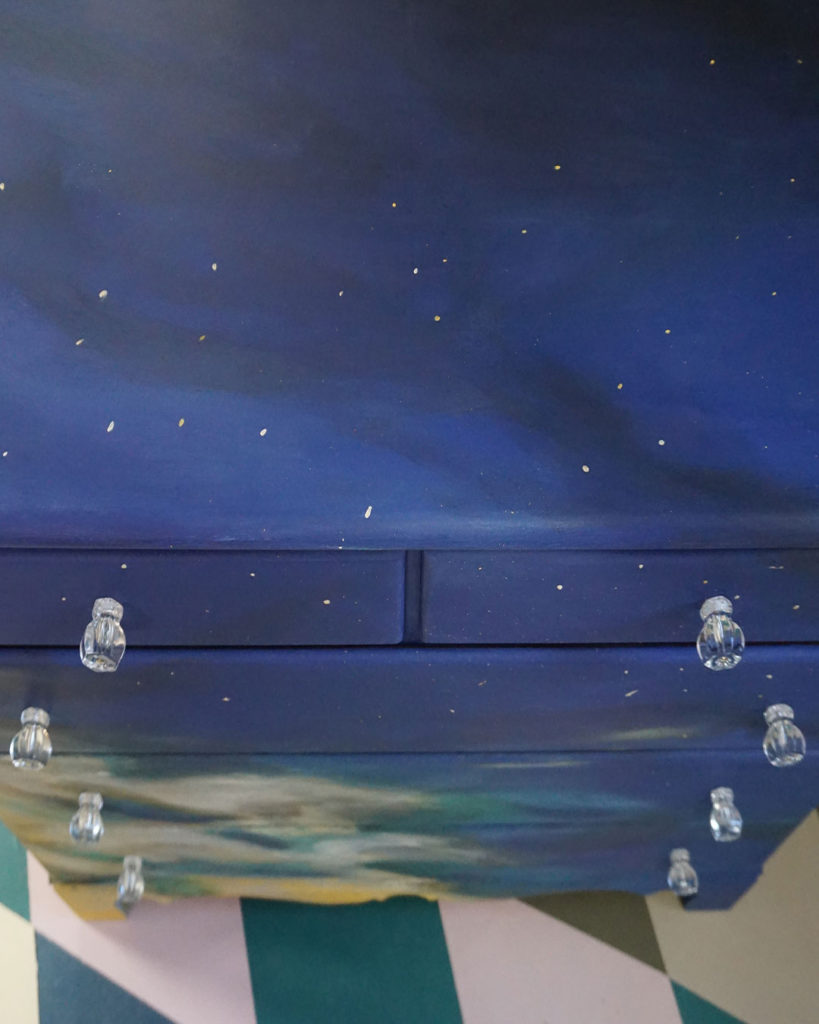 Komoda z namalowanym motywem nieba, autorstwa Malarki Rezydentki Annie Sloan, Olivii Lacy z Pigeon i Pip