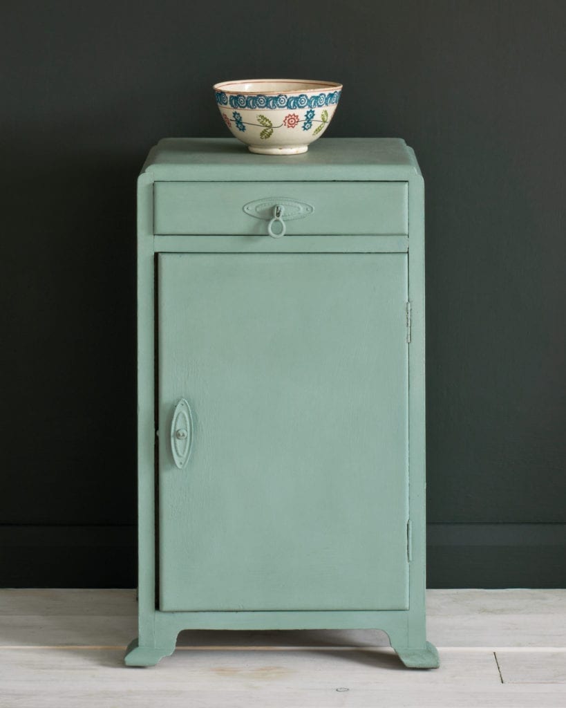Side table painted with Chalk Paint® in Duck Egg Blue, a greenish soft blue against a black wall of Graphite