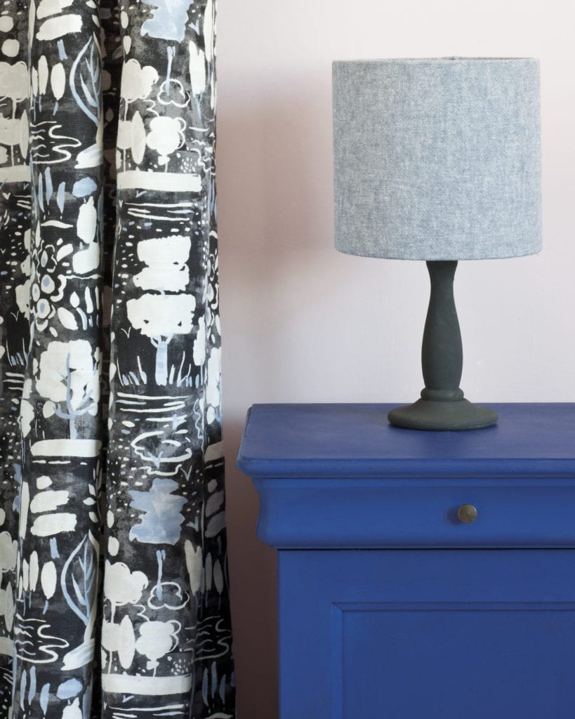 Side table painted with Chalk Paint® in Napoleonic Blue, a rich deep cobalt blue against a pink wall of Antoinette. Curtain in Dulcet in Graphite and Linen Union in Old Violet + Old White.