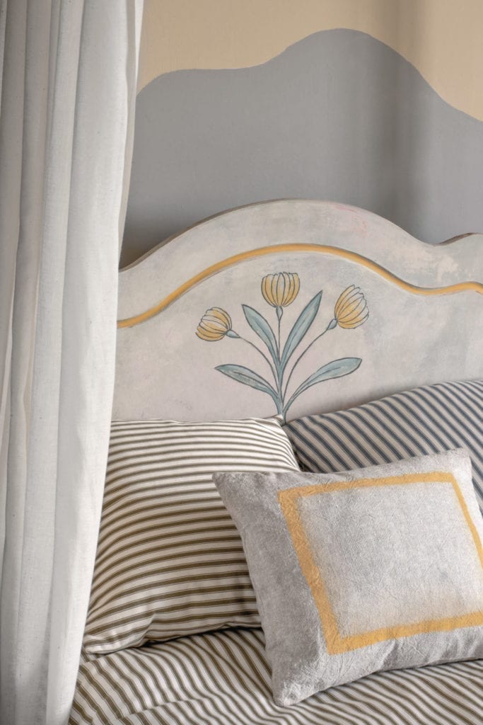 Swedish style four poster bed painted with Chalk Paint® by Annie Sloan in a tulip design. Cushions in Ticking fabrics