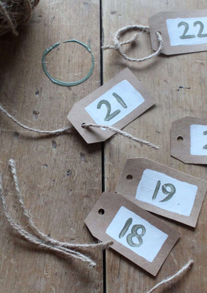 A Collection of Brown Paper Tags with Chalk Painted Numbers in Olive and Old White