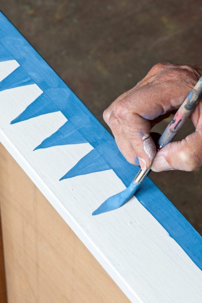 Annie Sloan using the Large Round Detail Brush with Chalk Paint® in Giverny on Old White Graphic Plan Chest Credit CICO Books Christopher Drake