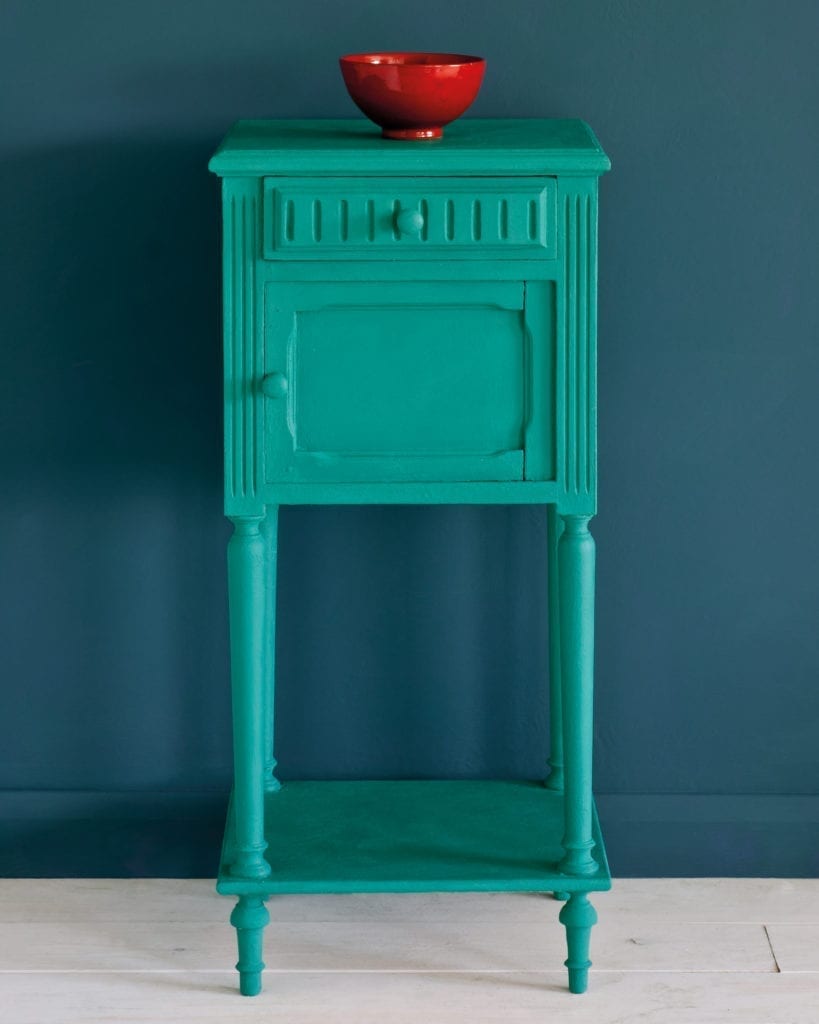 Side table painted with Chalk Paint® in Florence, a bright coppery green colour against a wall of Aubusson Blue