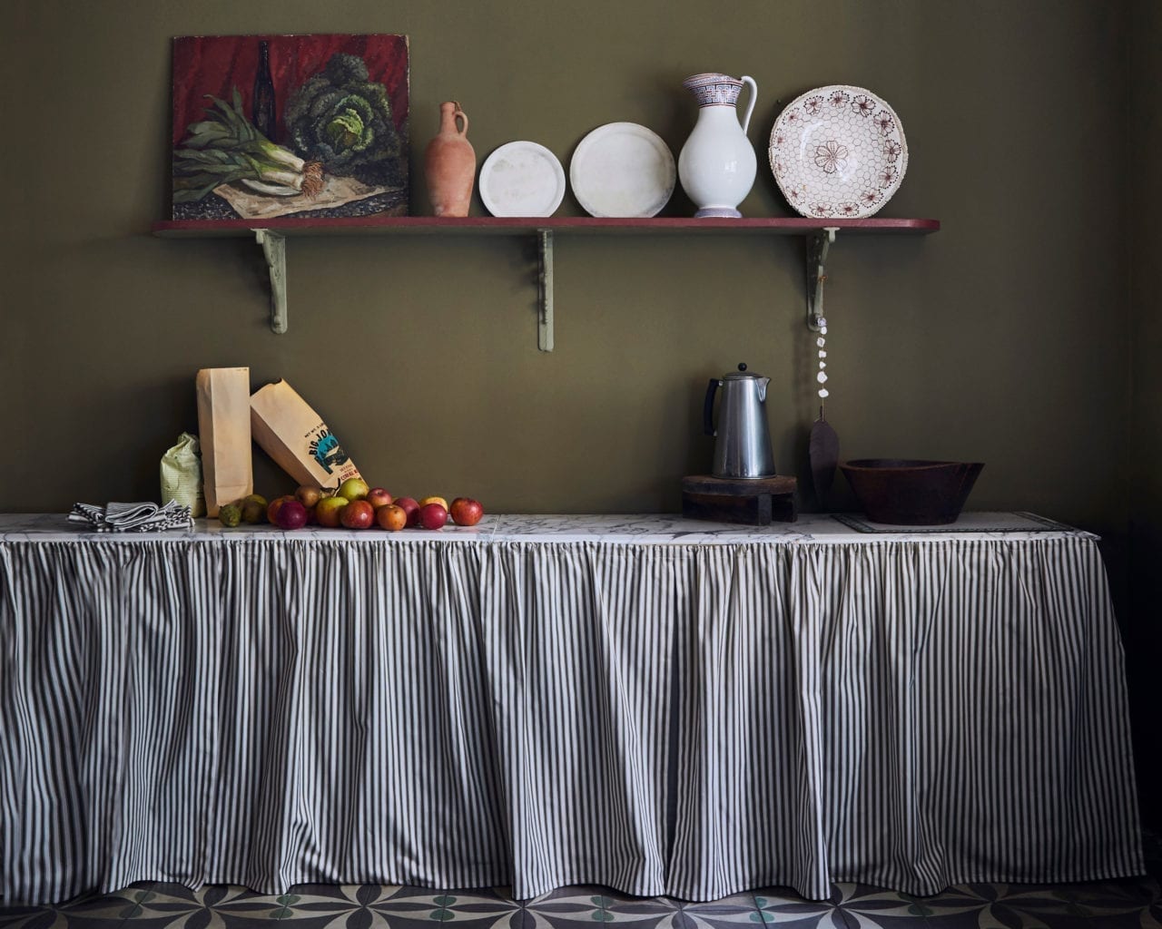 Kitchen painted with Chalk Paint in Olive and cabinet curtains in Ticking in Olive fabric by Annie Sloan