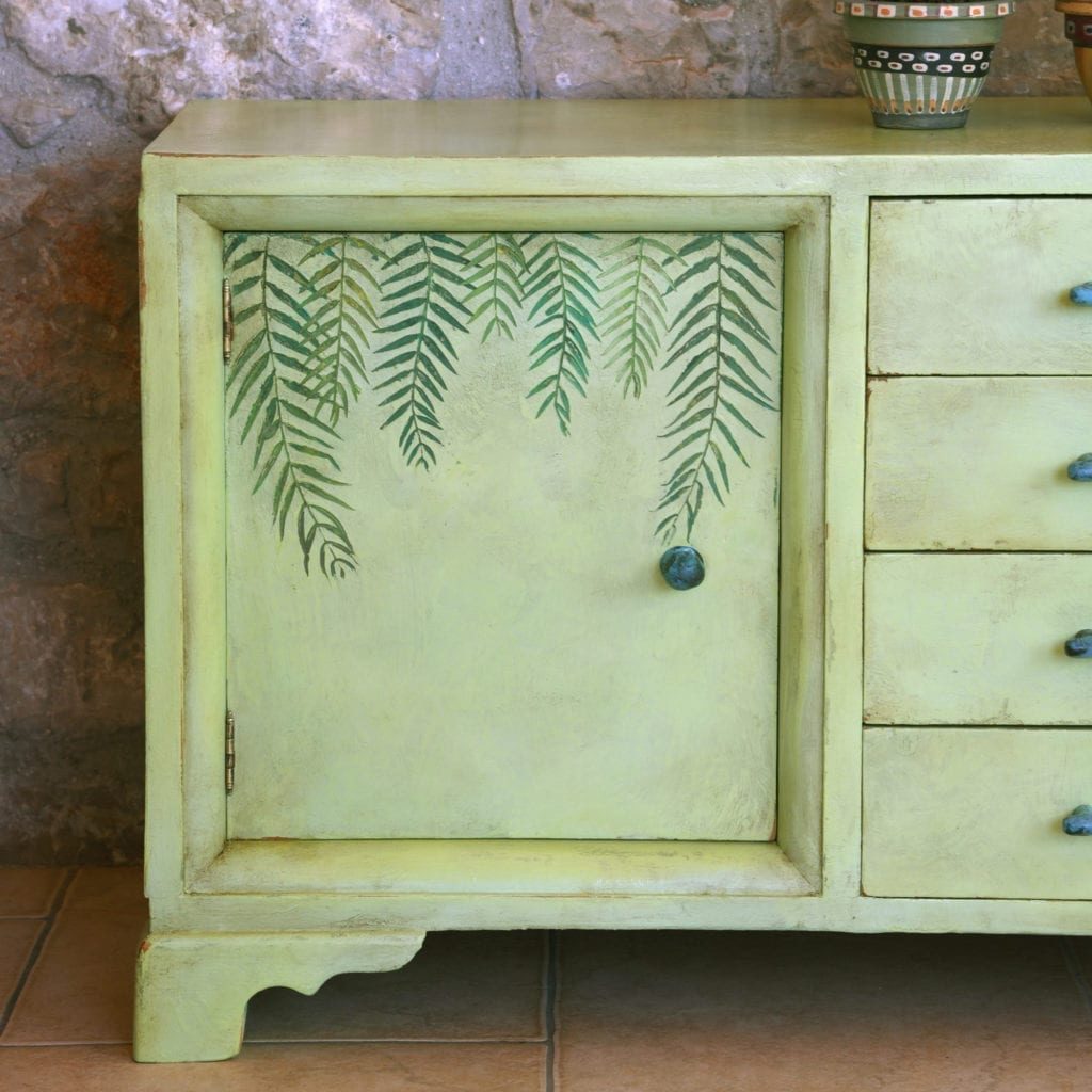 Nick Vardakas' low cabinet painted with Chalk Paint® by Annie Sloan in Lem Lem with hand-painted ferns and aged with Dark Wax