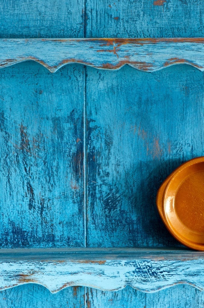 Distressed Kitchen Dresser painted with Chalk Paint® by Annie Sloan in Greek Blue, Napoleonic Blue and Primer Red. Wall in Scandinavian Pink.