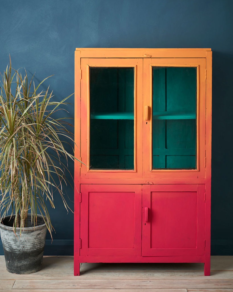 Capri Pink and Barcelona Orange Chalk Paint® ombre cabinet pops against the Aubusson Blue Chalk Paint® wall