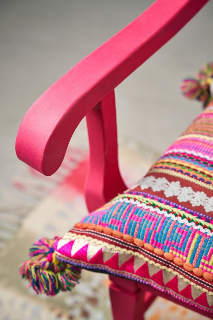 Close up of an Indian inspired wooden chair painted by Annie Sloan in Capri Pink Chalk Paint®