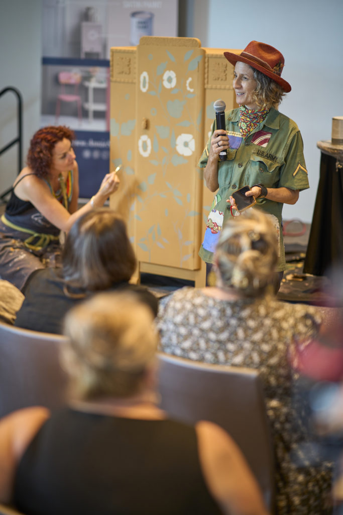 Furniture painter, Dingley Dell Creative, giving a folk art decorative painting demonstration on stage at the Big Paint event in New Orleans