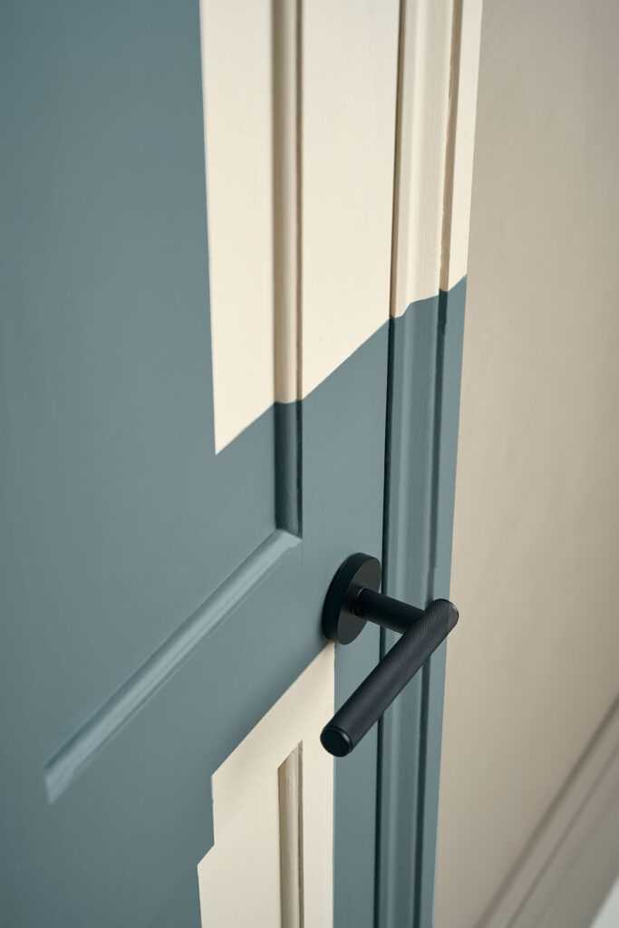 Annie Sloan Satin paint used to create square pattern on interior door, close up of Plank black handle