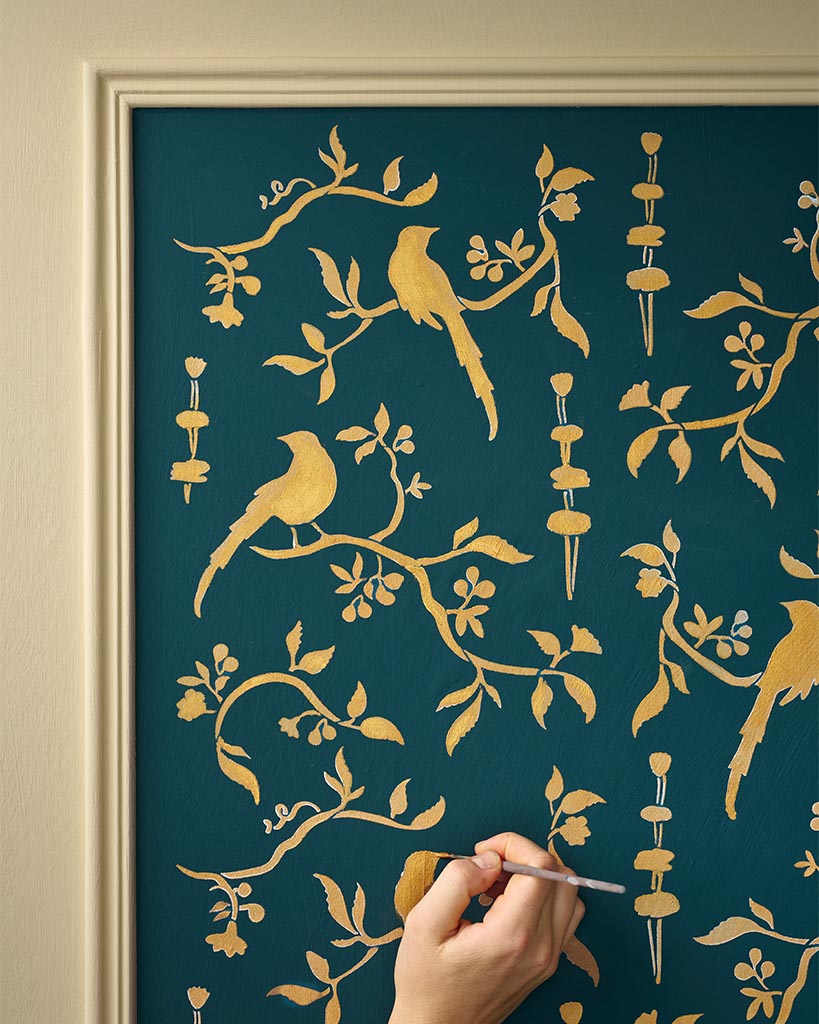 Painting the stencil design with metallic gold
