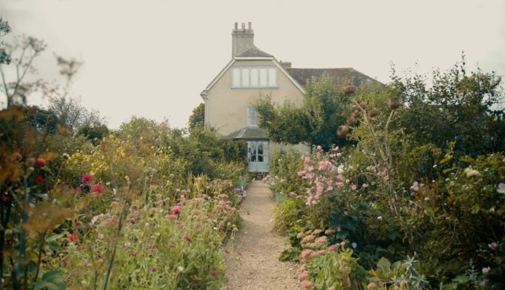 The front of Charleston Farmhouse with flowers in summer