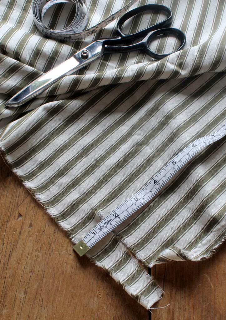 Ticking in Olive Fabric, Measuring Tape, and Scissors