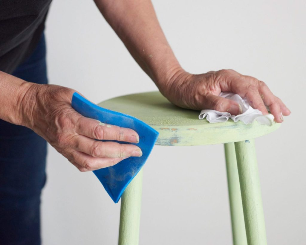 Annie Sloan sanding a two colour distress on a stool painted with Chalk Paint in Lem Lem and Aubusson Blue CREDIT Tina Hillier with Oxfam