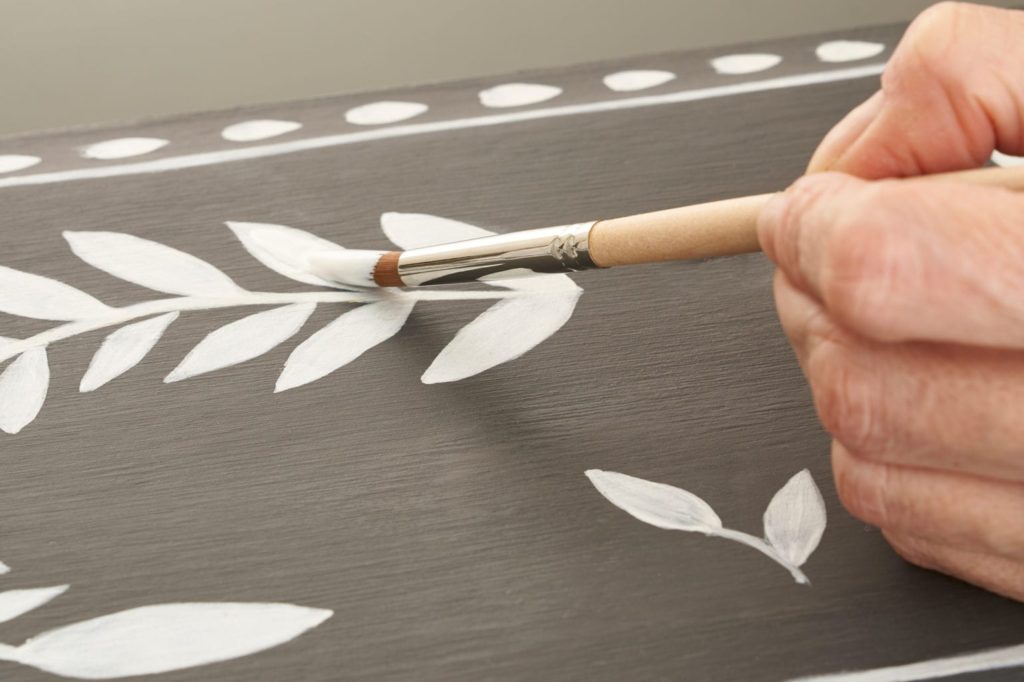Bone Inlay Leaf shapes being painted onto Chalk Paint® in Graphite
