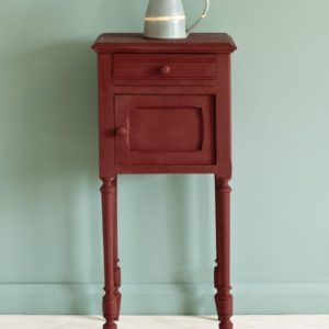 Side table painted with Chalk Paint® in Primer Red, a deep, red ochre against a wall of Duck Egg Blue